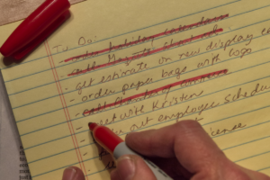 Inventário do essencial representado por lista de prioridades sendo organizada sobre mesa minimalista.